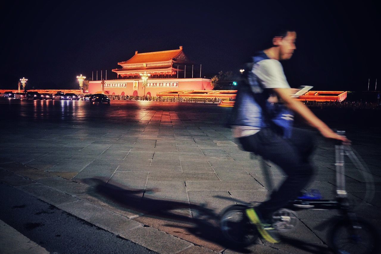 WOMAN STANDING IN CITY AT NIGHT