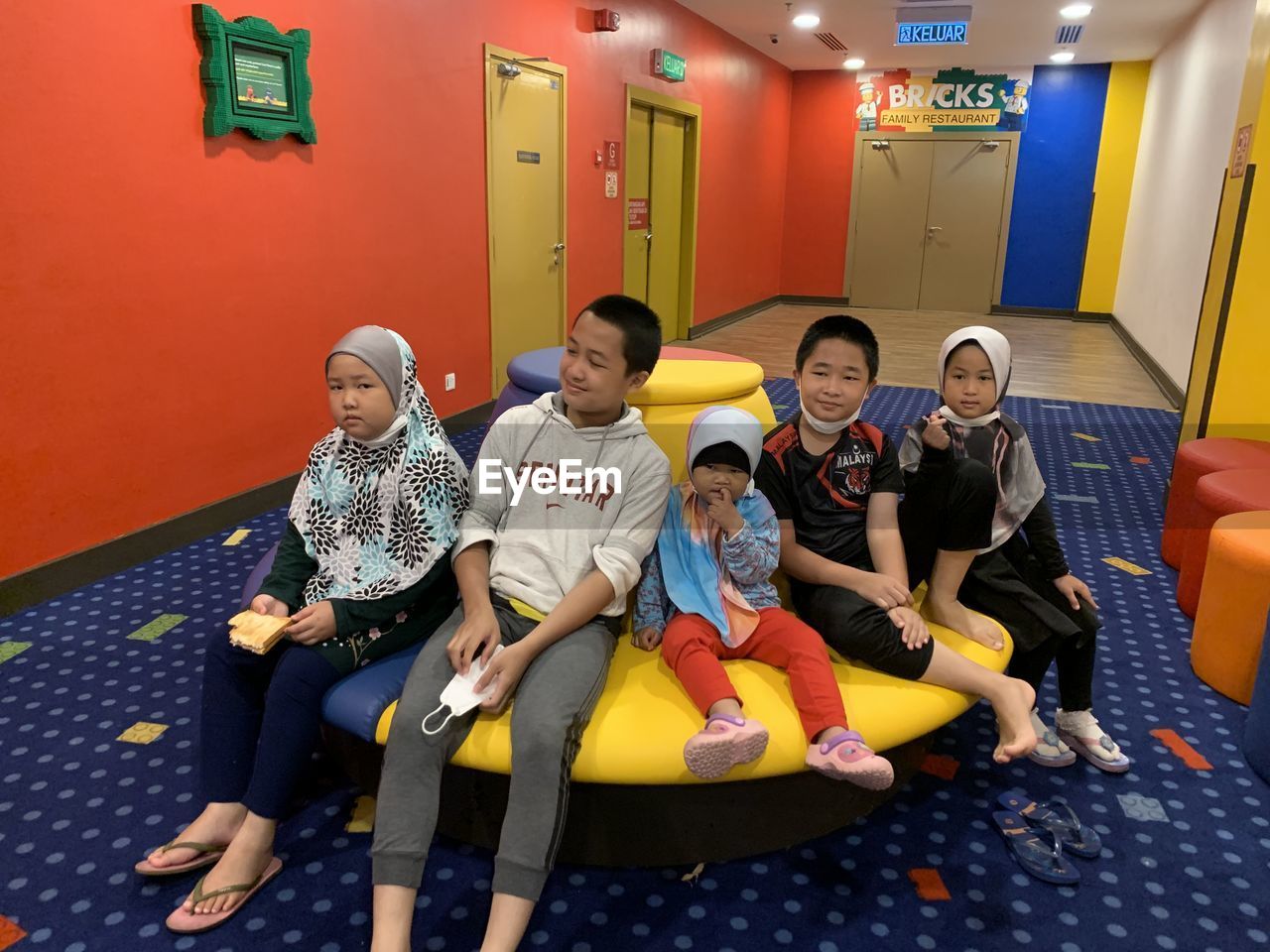 group of people, men, child, sitting, adult, childhood, women, full length, female, indoors, room, togetherness, friendship, smiling, happiness, lifestyles, relaxation, education, sports, architecture, fun, leisure activity, emotion