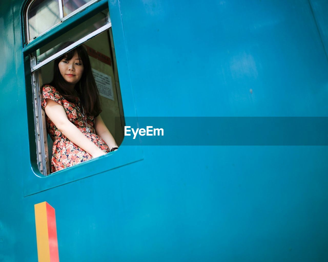 Low angle view of woman looking through train window