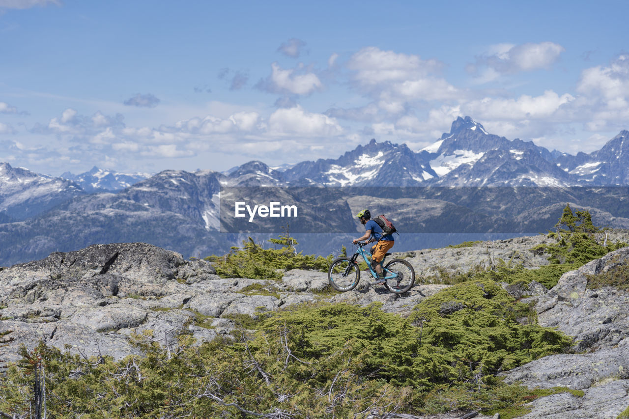 PERSON RIDING BICYCLE ON MOUNTAIN