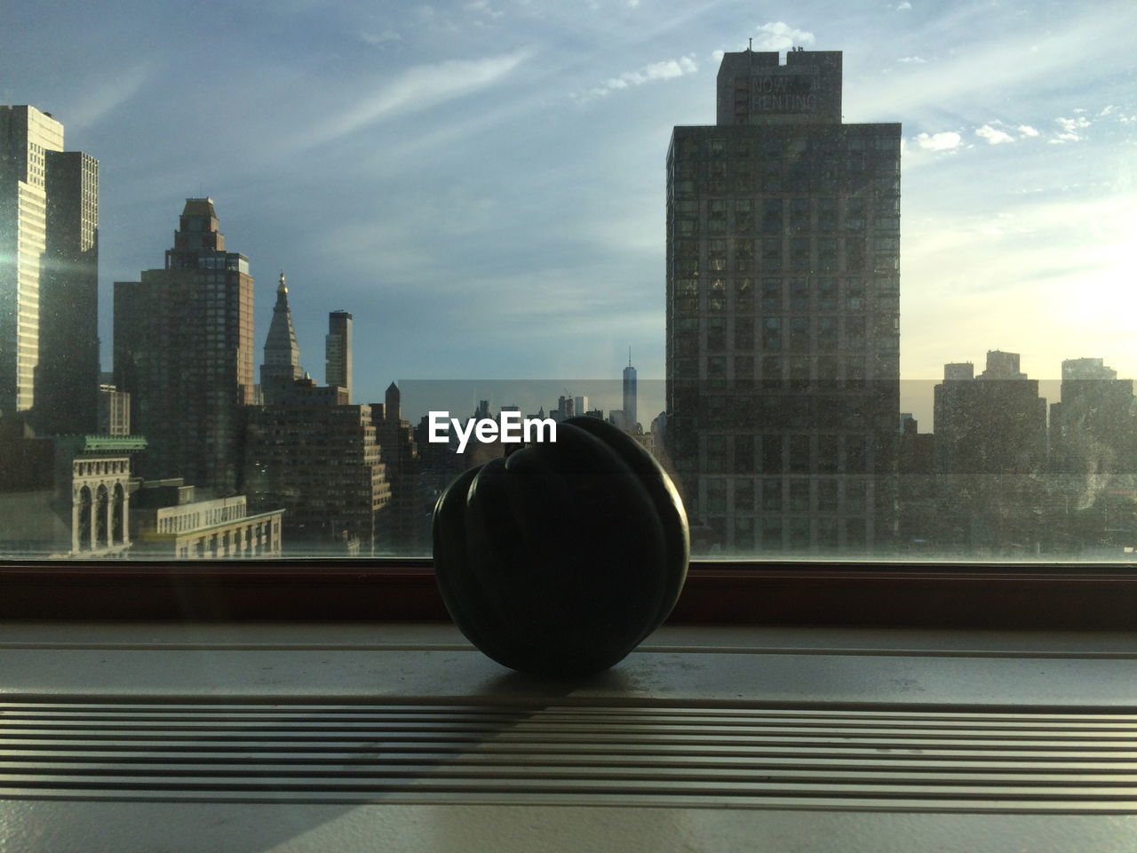 Close-up of pumpkin on window sill against buildings