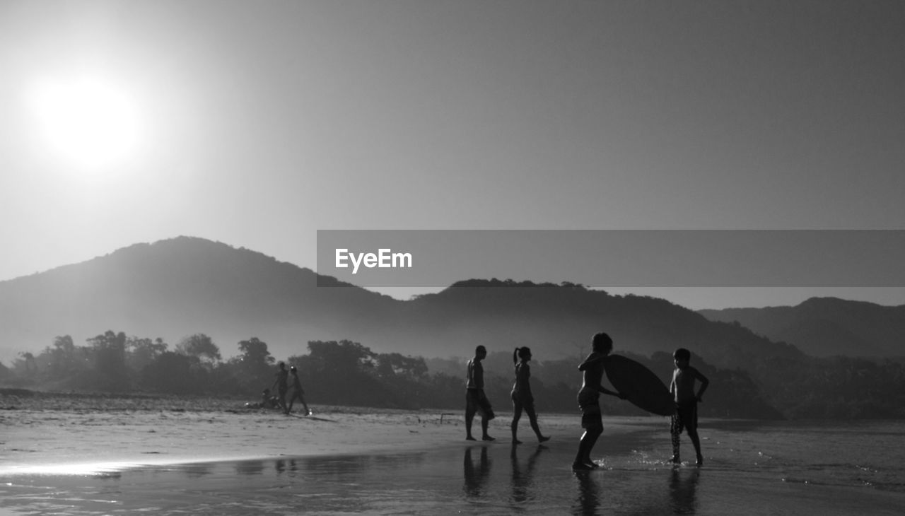 PEOPLE ON BEACH AGAINST SKY