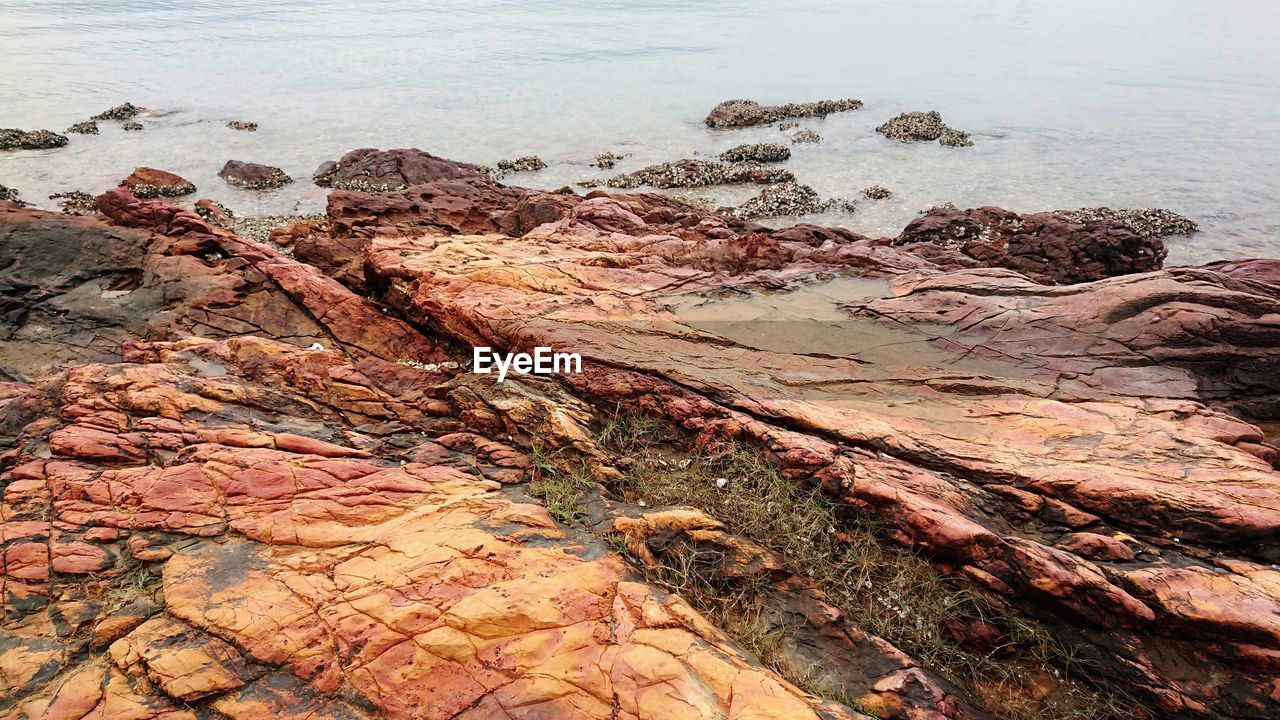 HIGH ANGLE VIEW OF ROCKS ON SHORE AT SEA