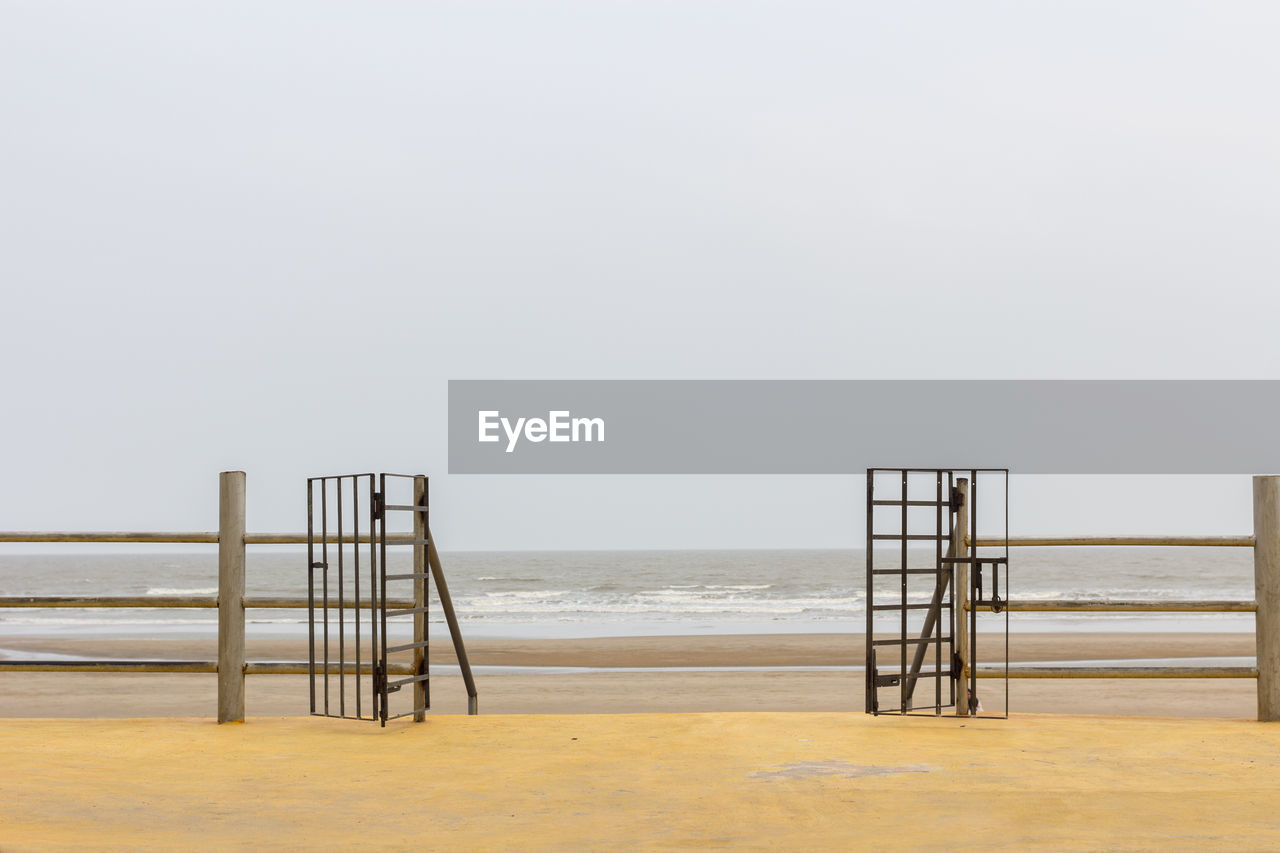 Wooden posts on beach against clear sky