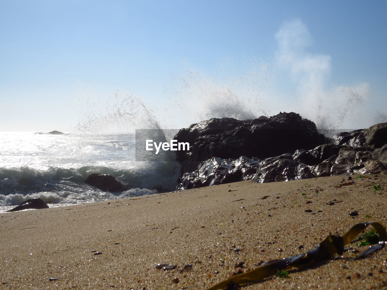 Waves splashing on rocks at shore 