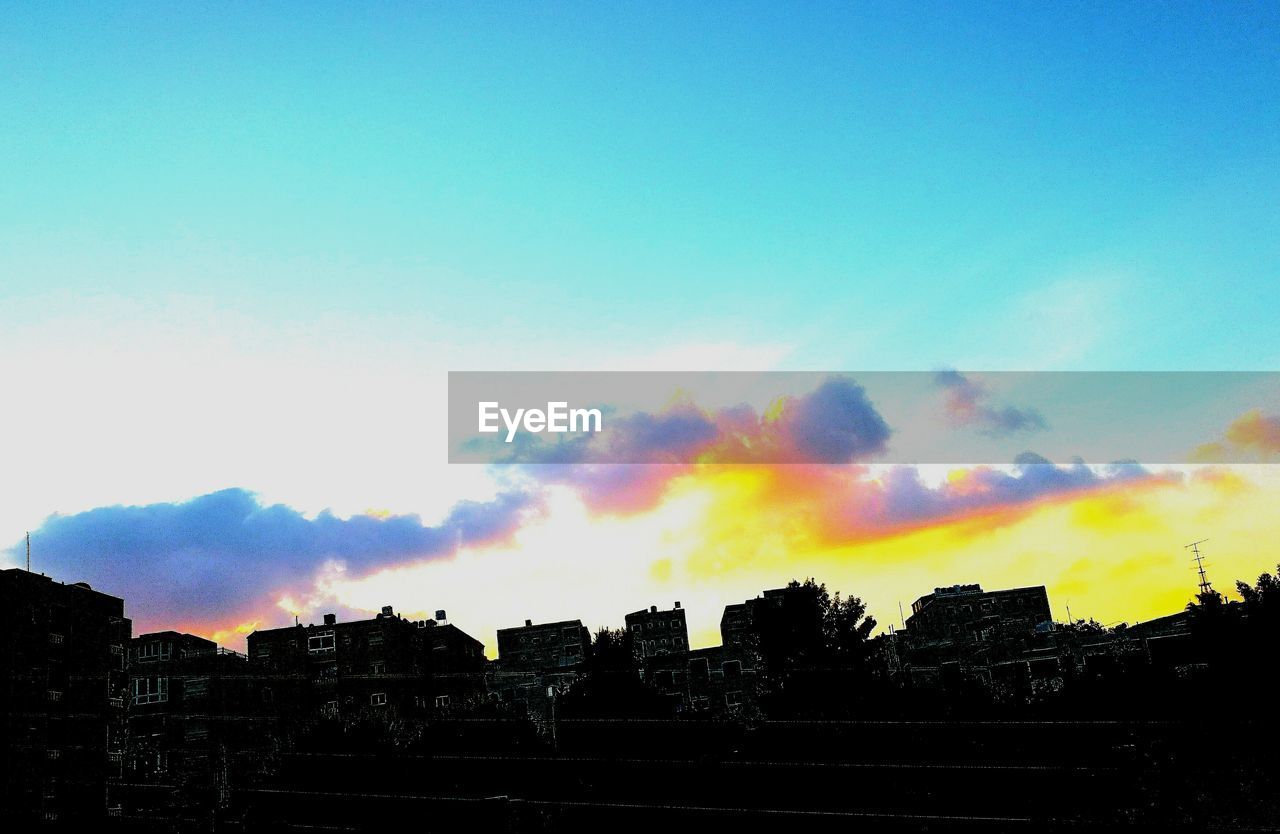 SILHOUETTE BUILDINGS AGAINST SKY DURING SUNSET