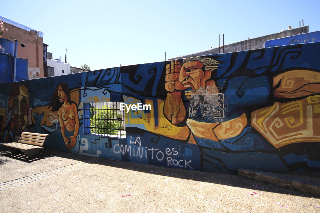 graffiti, art, creativity, architecture, street art, urban area, built structure, city, mural, day, building exterior, sky, wall - building feature, no people, multi colored, clear sky, nature, sunlight, outdoors, text, wall, street, road, painting, vandalism, spray paint, blue, sunny