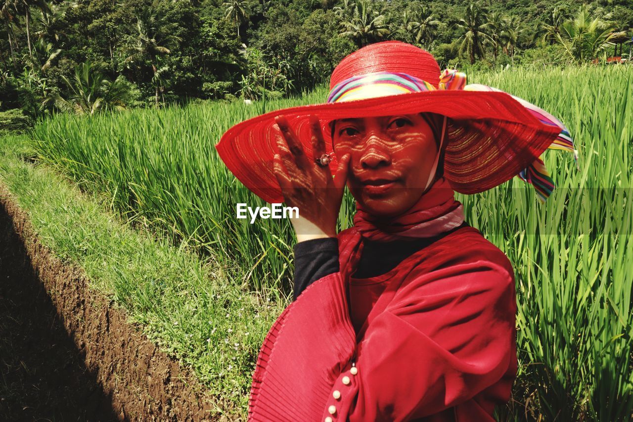 Rear view of woman wearing hat standing on field