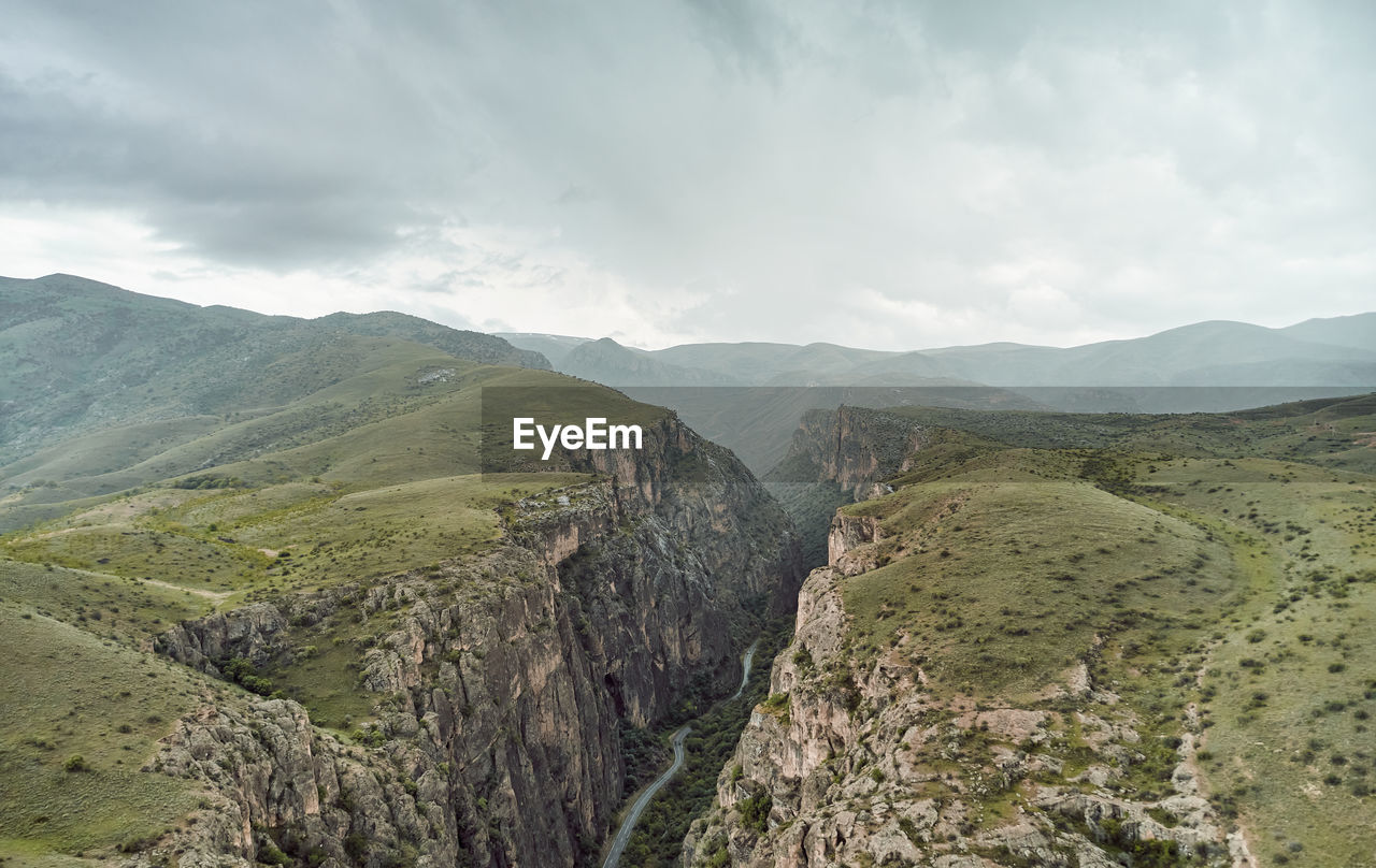 scenic view of mountains against cloudy sky