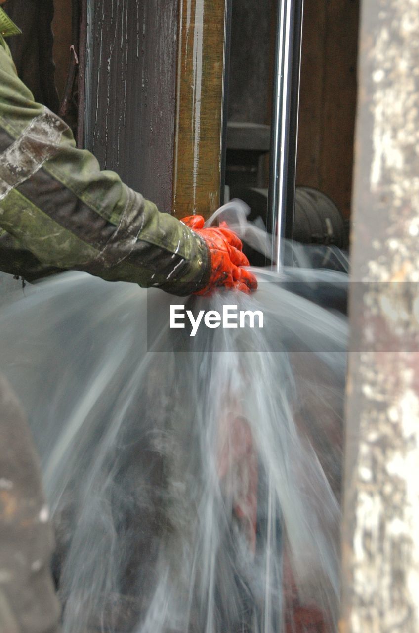 Cropped hands of worker with blurred water