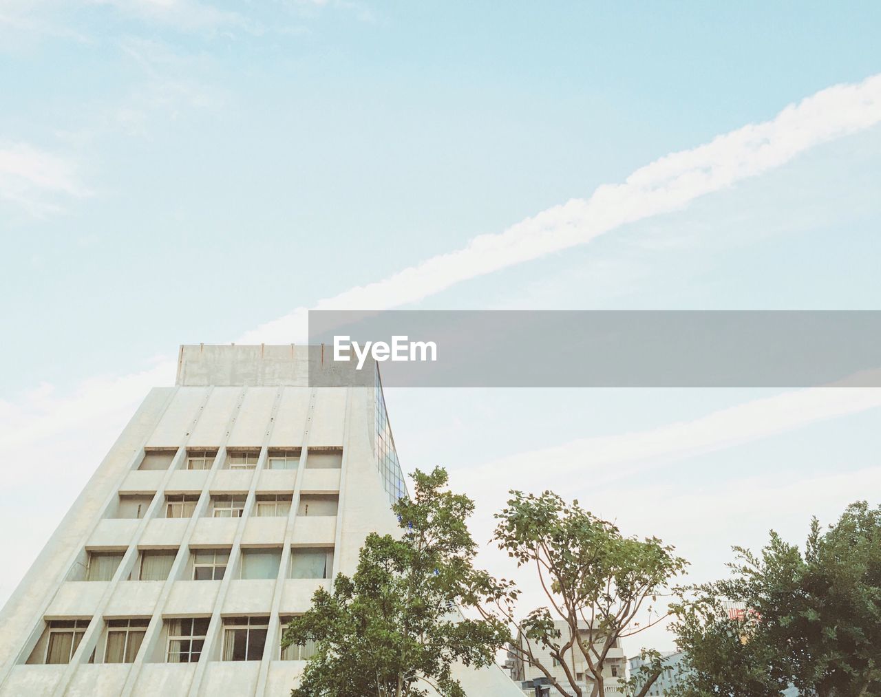 Low angle view of building and trees against sky