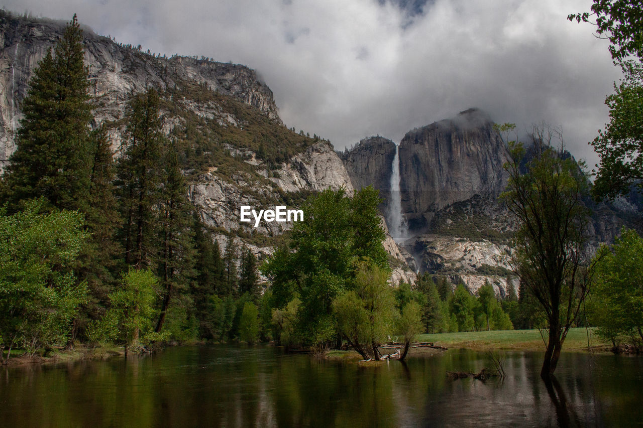 Scenic view of lake by trees against sky