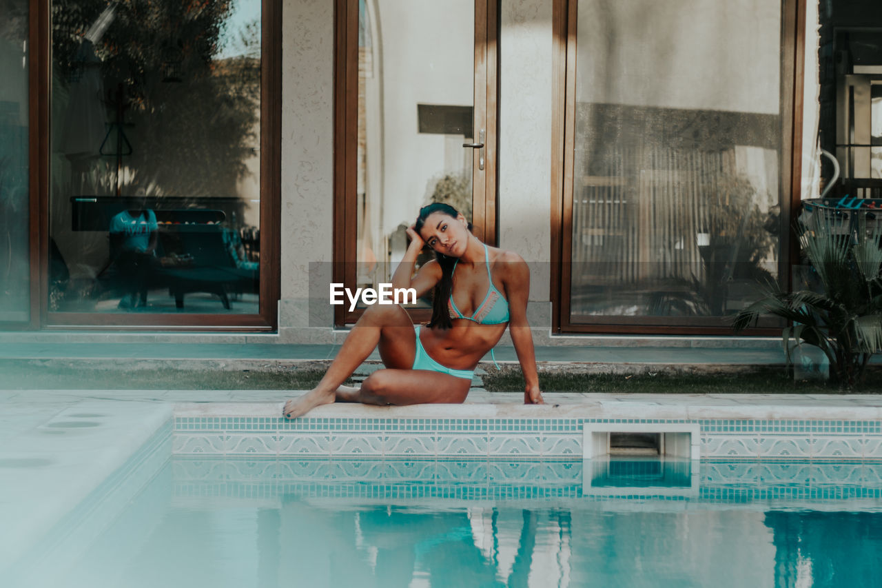 WOMAN SITTING IN SWIMMING POOL