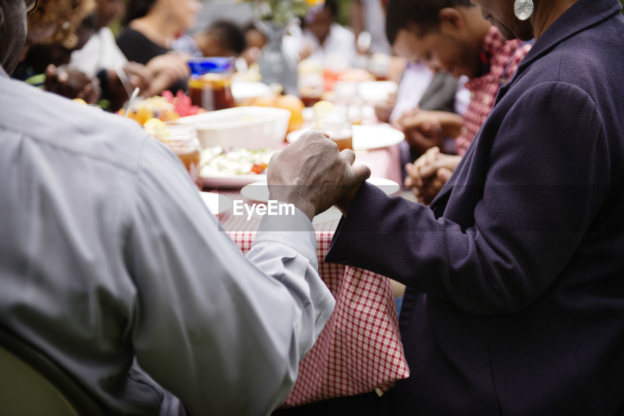 Senior couple holding hands on picnic table