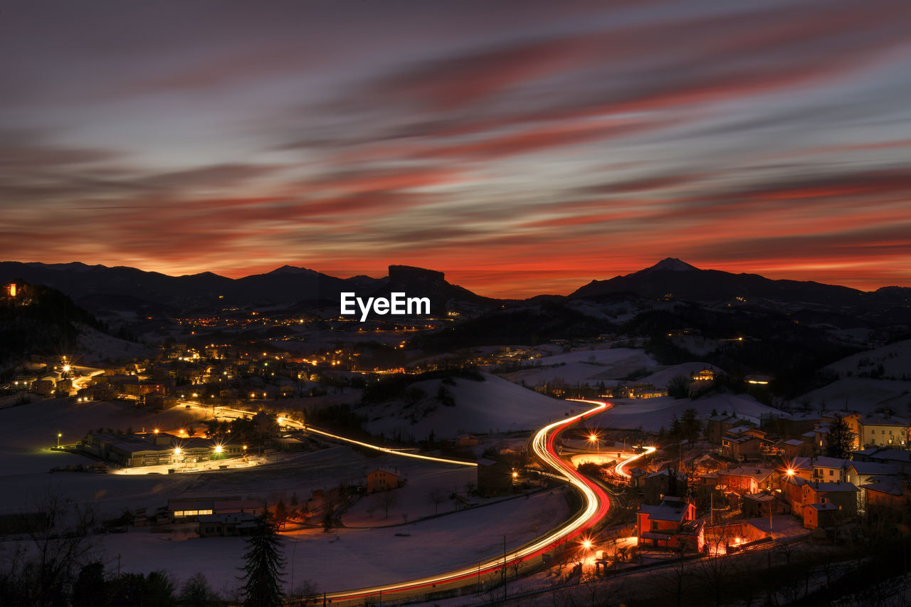 High angle view of illuminated cityscape against sky during sunset