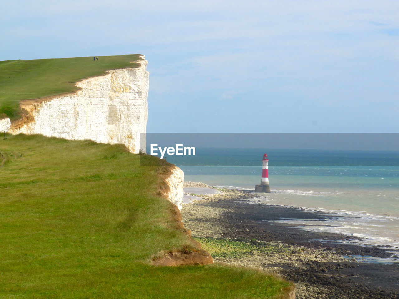 Scenic view of mountain cliff and sea against sky