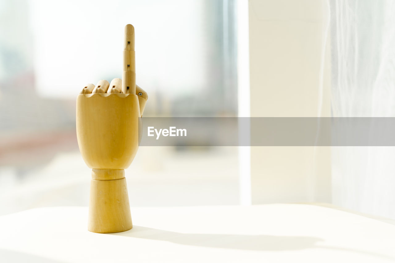 A wooden hand point finger up.