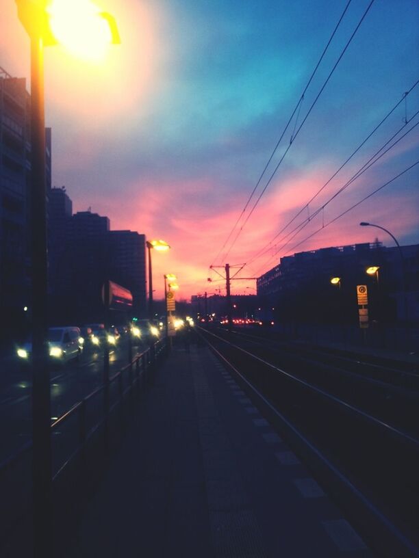 RAILROAD TRACKS IN CITY AT SUNSET