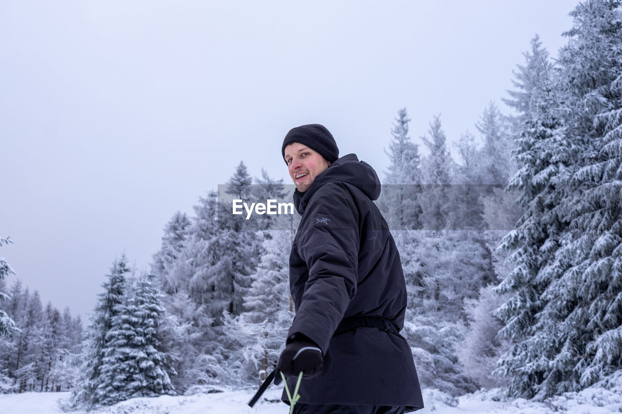 Portrait of man standing on snow covered landscape