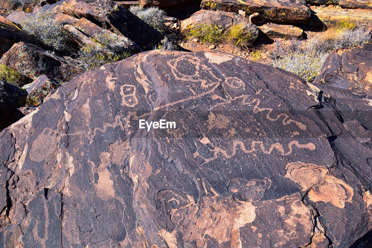 rock, geology, nature, boulder, soil, no people, day, high angle view, wilderness, sunlight, text, outdoors, land, travel destinations, leaf, communication, rock formation