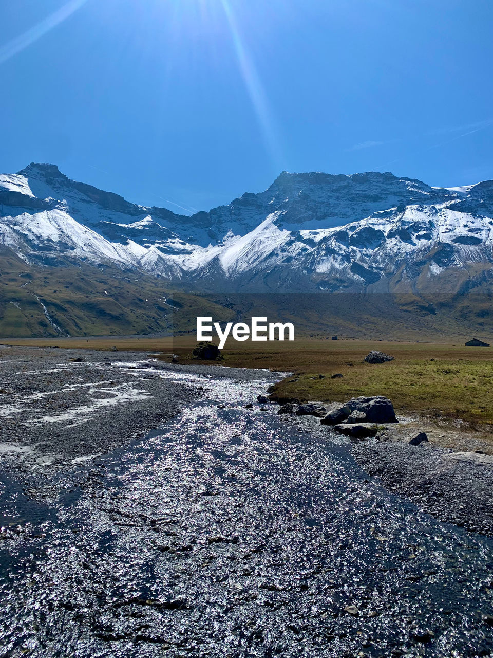 snow, cold temperature, mountain, environment, landscape, winter, scenics - nature, beauty in nature, sky, snowcapped mountain, nature, mountain range, ice, travel, land, travel destinations, frozen, no people, tranquility, blue, tranquil scene, water, glacier, sunlight, non-urban scene, sun, tourism, polar climate, wilderness, outdoors, sunny, plateau, cloud, mountain peak, day, idyllic, sunbeam, glacial landform, social issues