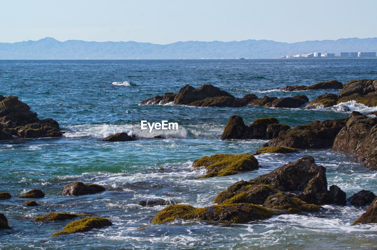 ROCKS ON BEACH AGAINST SKY