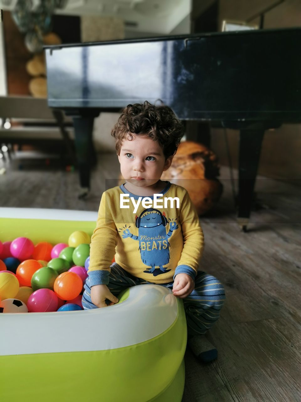 PORTRAIT OF CUTE BOY PLAYING WITH MULTI COLORED BALLOONS