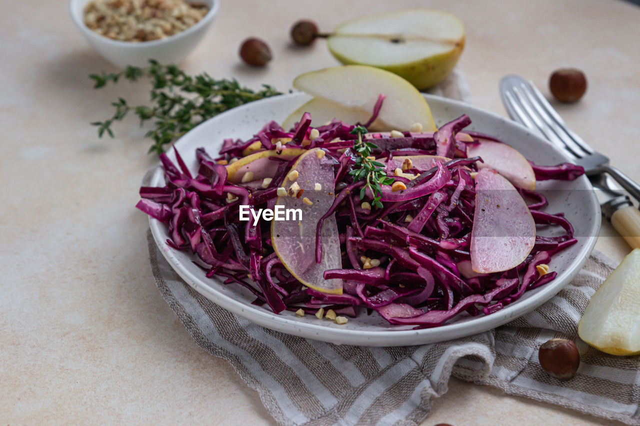 Red cabbage, pear and hazelnut salad with lemon and olive oil sauce.  vegetarian food. 