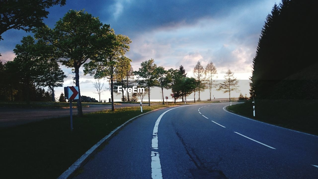 EMPTY ROAD BY TREES AGAINST SKY