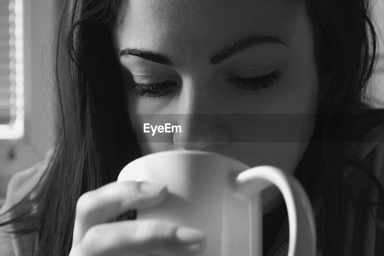 Close-up of young woman drinking coffee