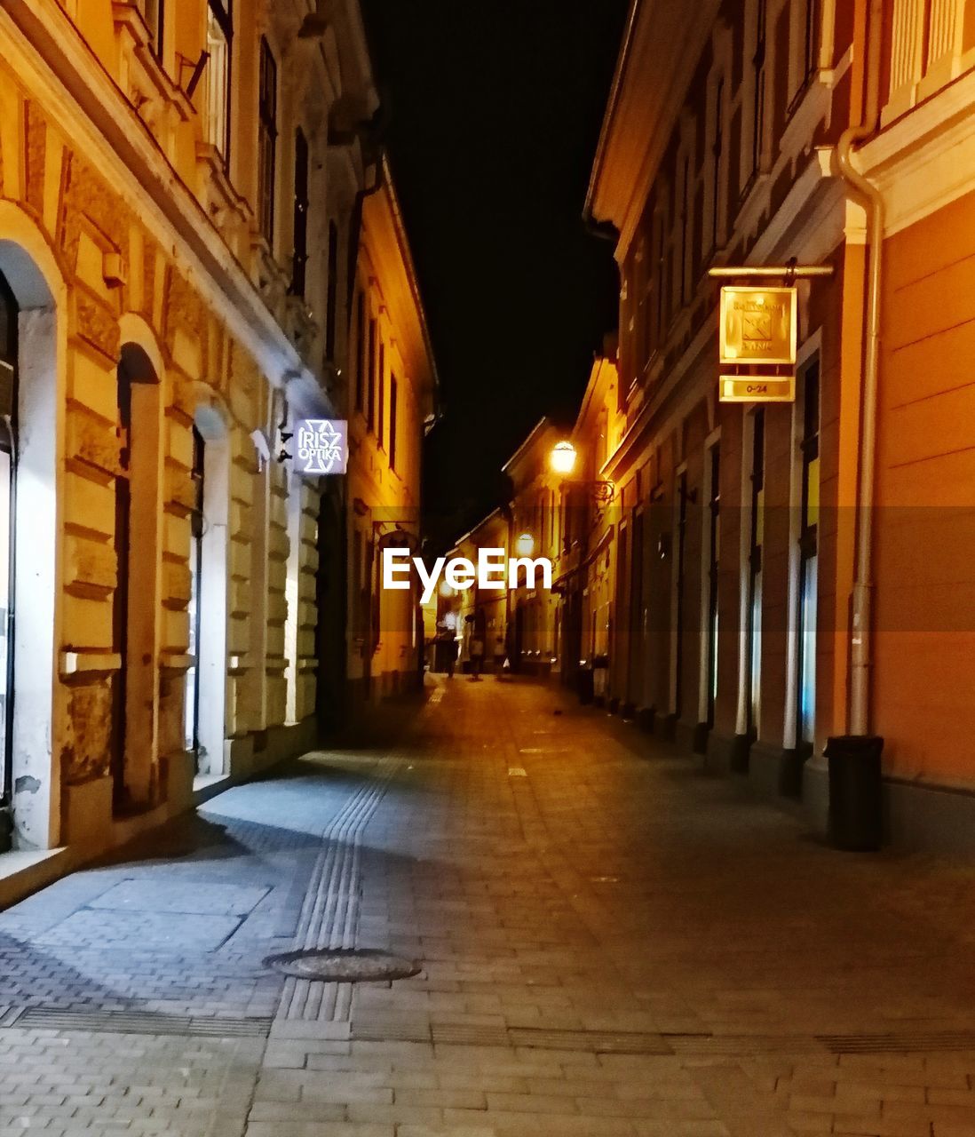 EMPTY ALLEY AMIDST BUILDINGS AT NIGHT