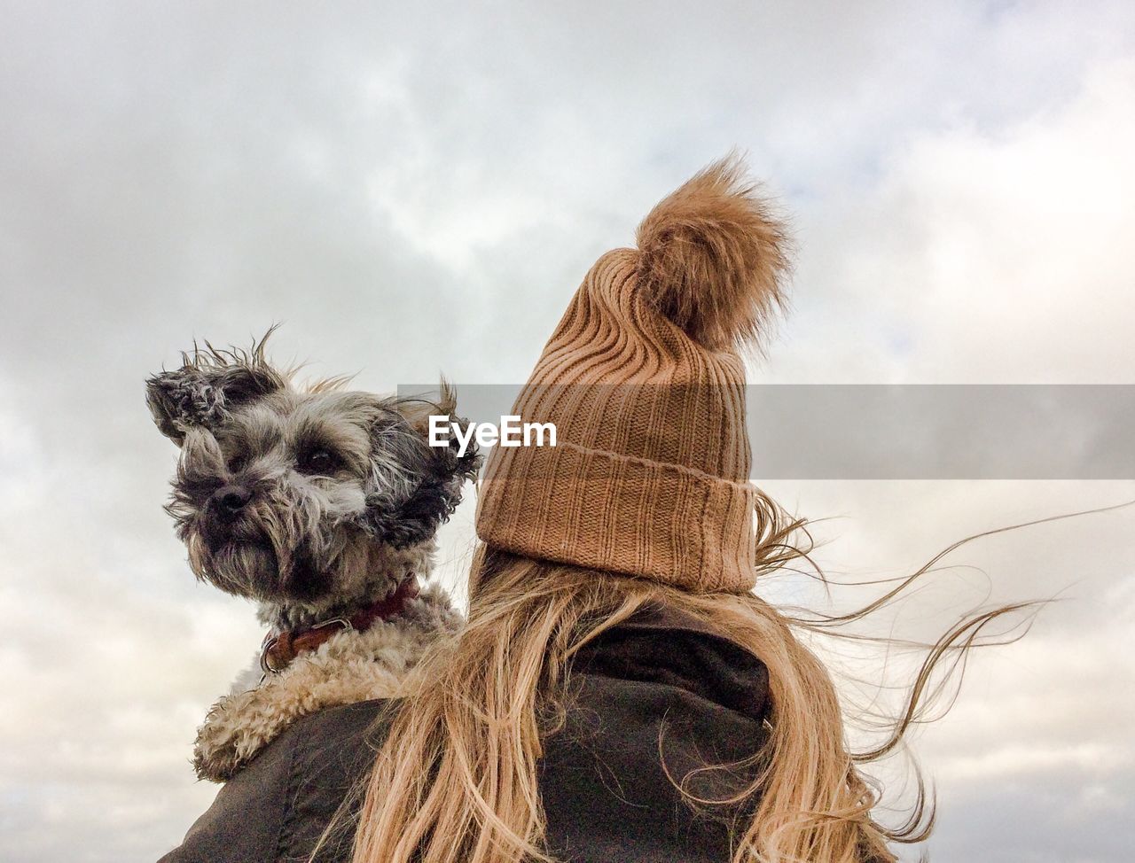 Low angle view of woman with dog against sky