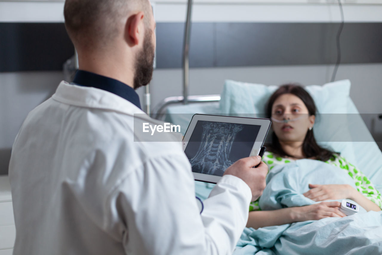 Doctor talking to patient while holding tablet pc