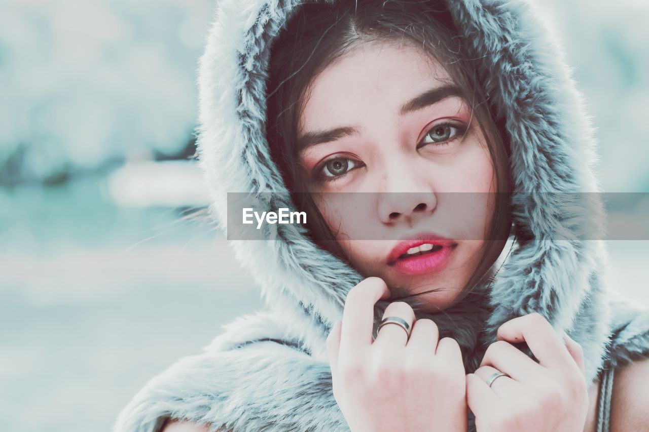 Close-up portrait of young woman wearing fur coat