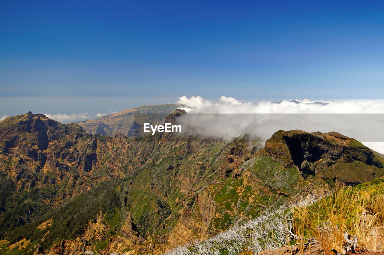 Scenic view of rocky mountains against blue sky