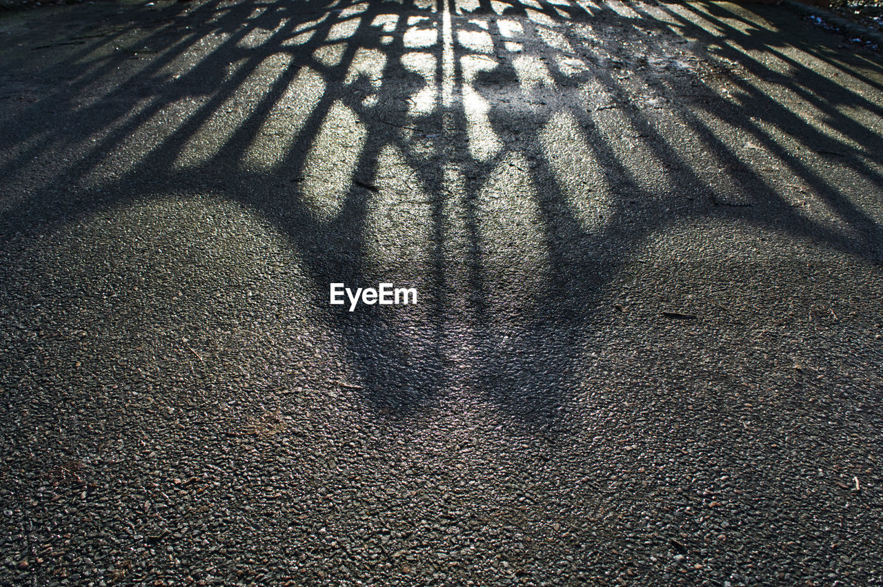 HIGH ANGLE VIEW OF SHADOW ON SAND AT STREET