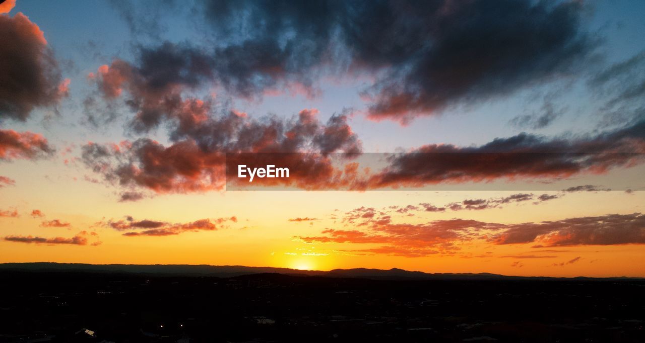 SILHOUETTE LANDSCAPE AGAINST DRAMATIC SKY DURING SUNSET