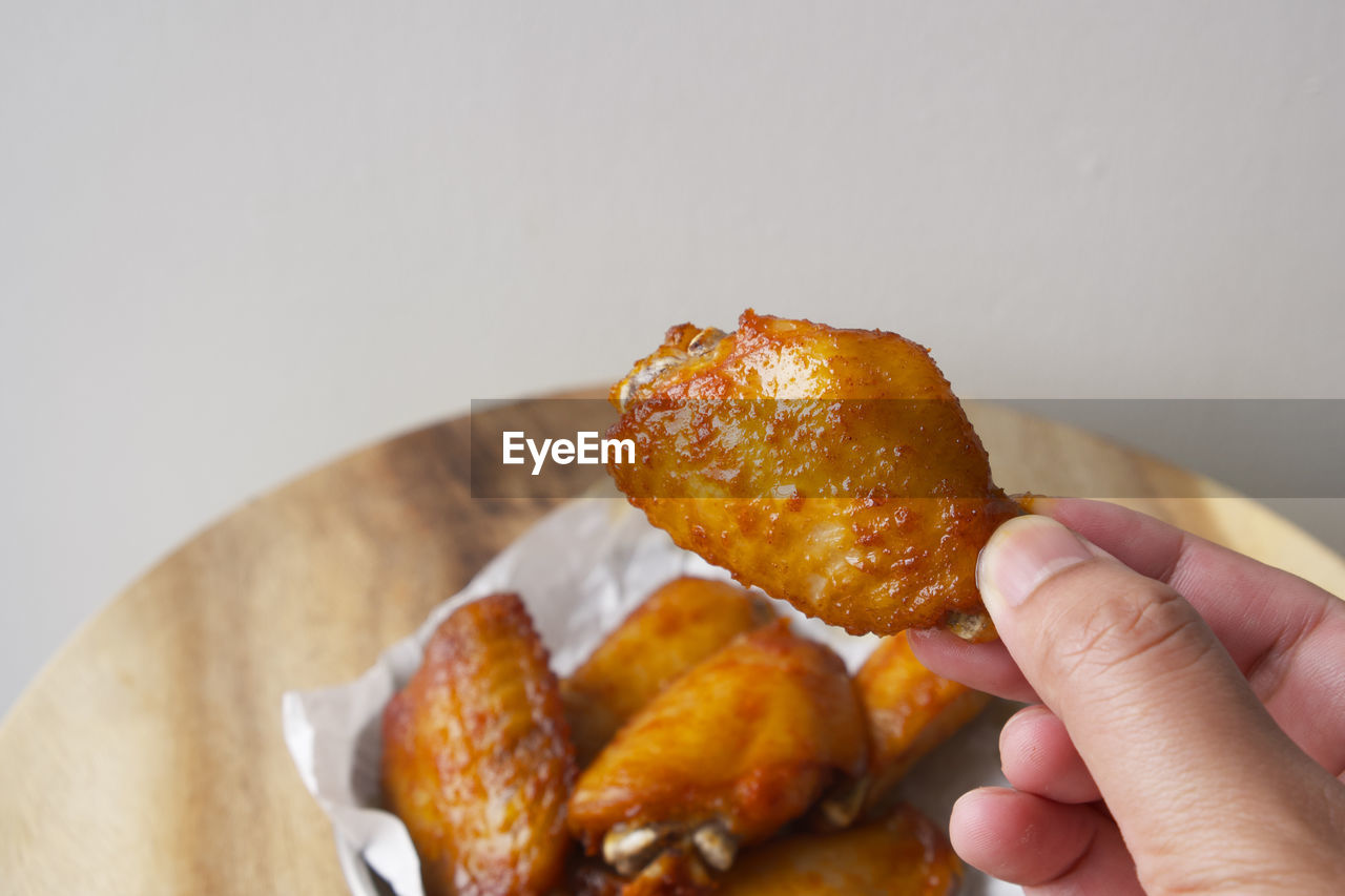 CLOSE-UP OF HAND HOLDING BREAD