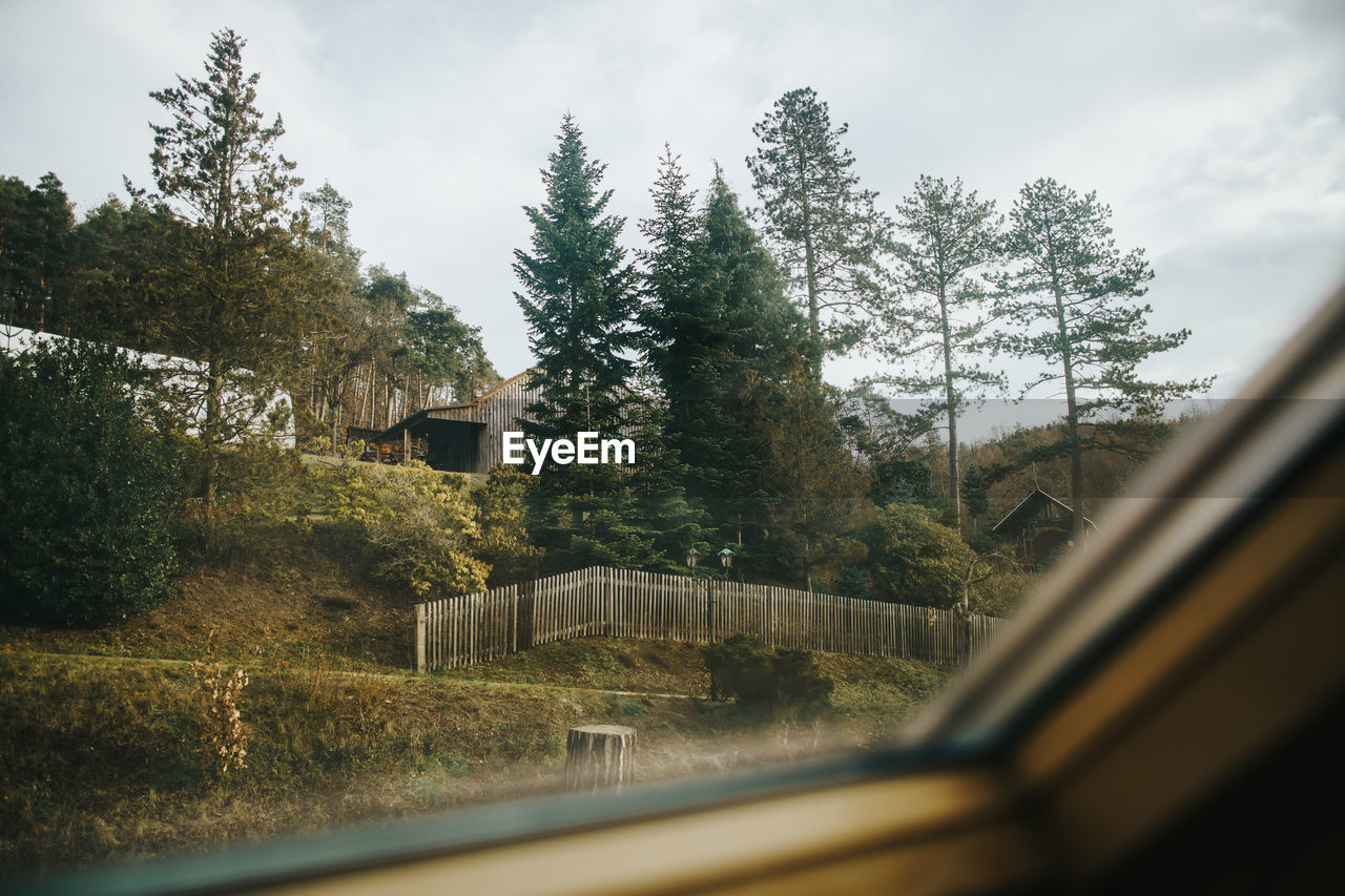 Rural landscape with barn and trees seen through window