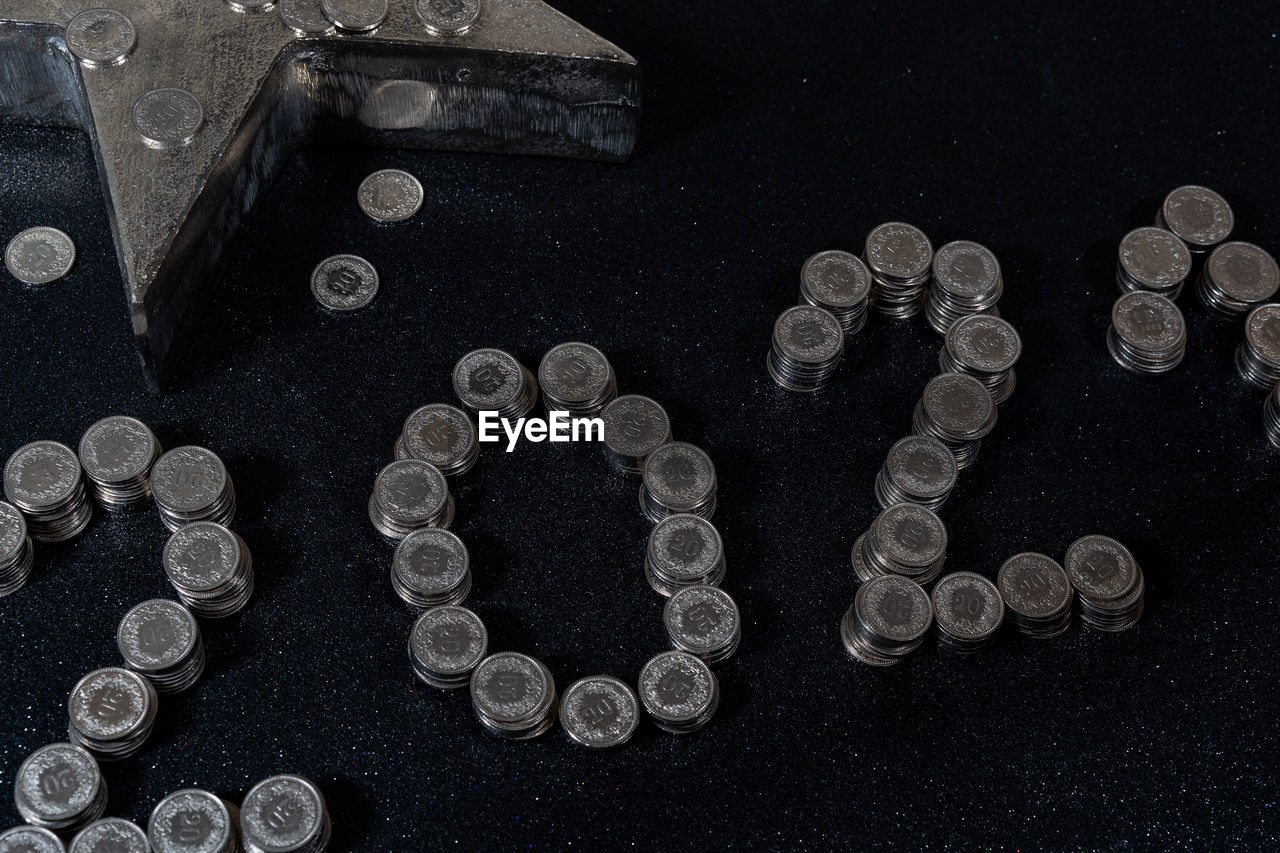 HIGH ANGLE VIEW OF COINS ON BLACK BACKGROUND