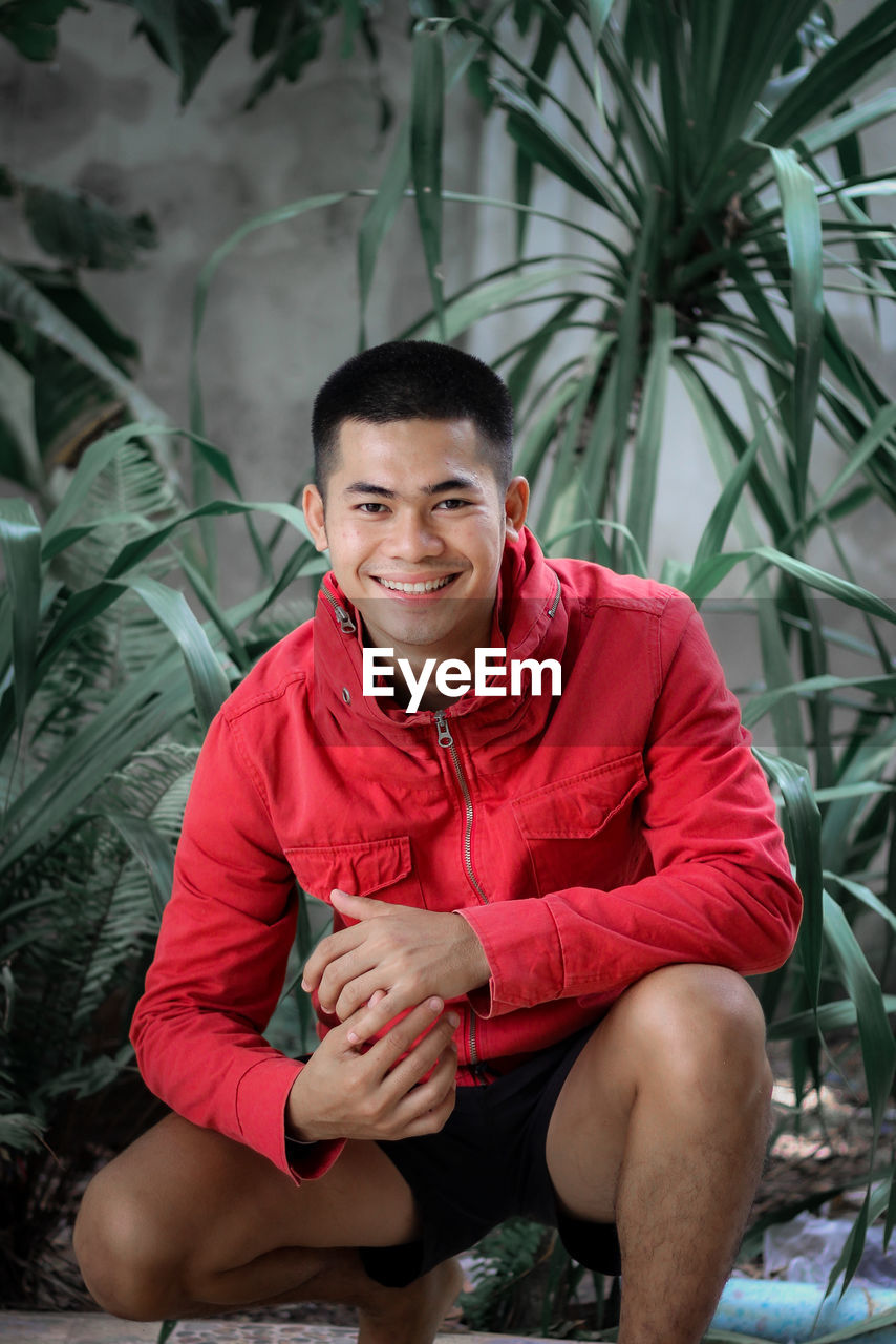 Portrait of smiling young man sitting outdoors