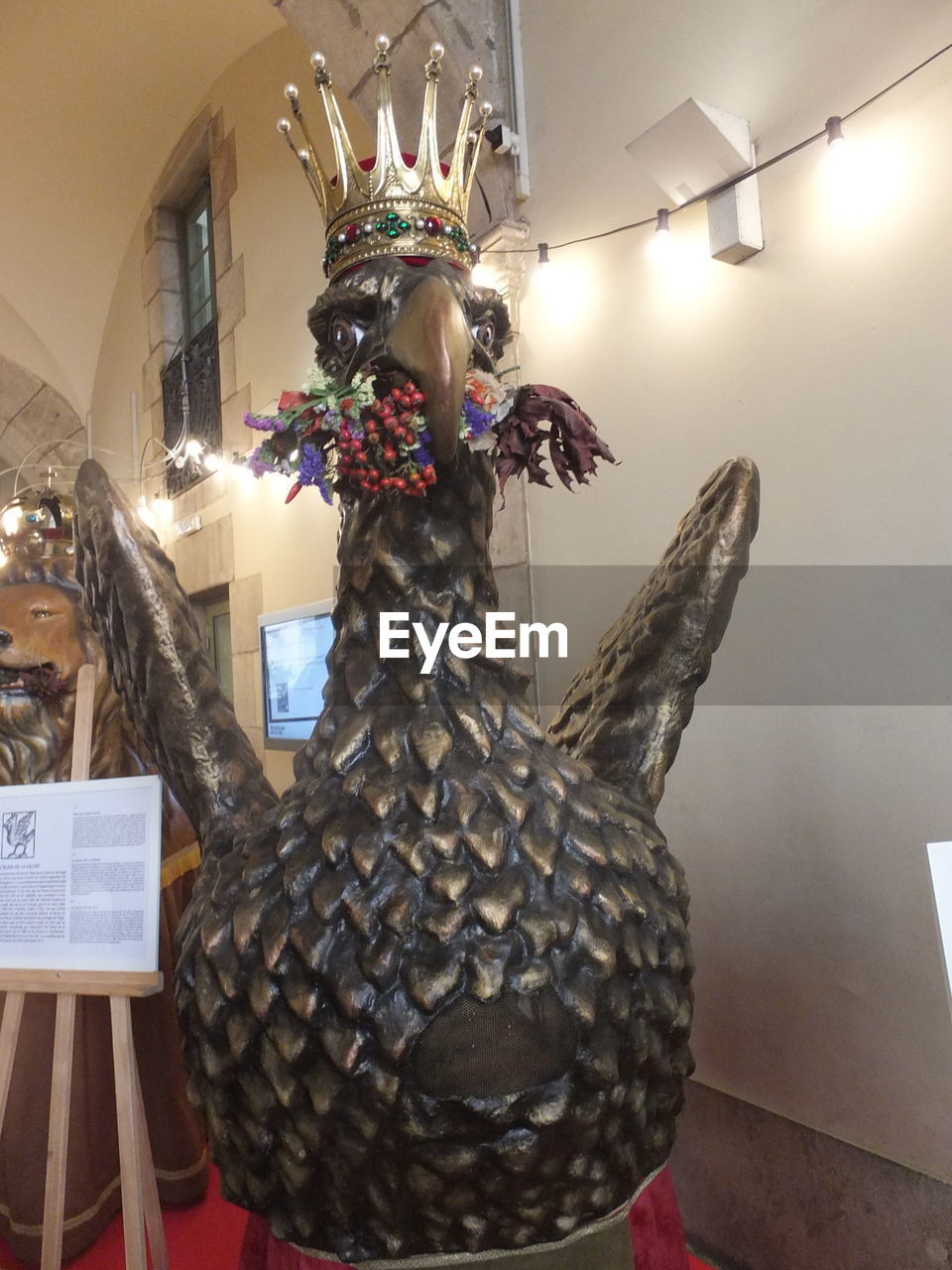 LOW ANGLE VIEW OF ILLUMINATED STATUE HANGING IN CEILING