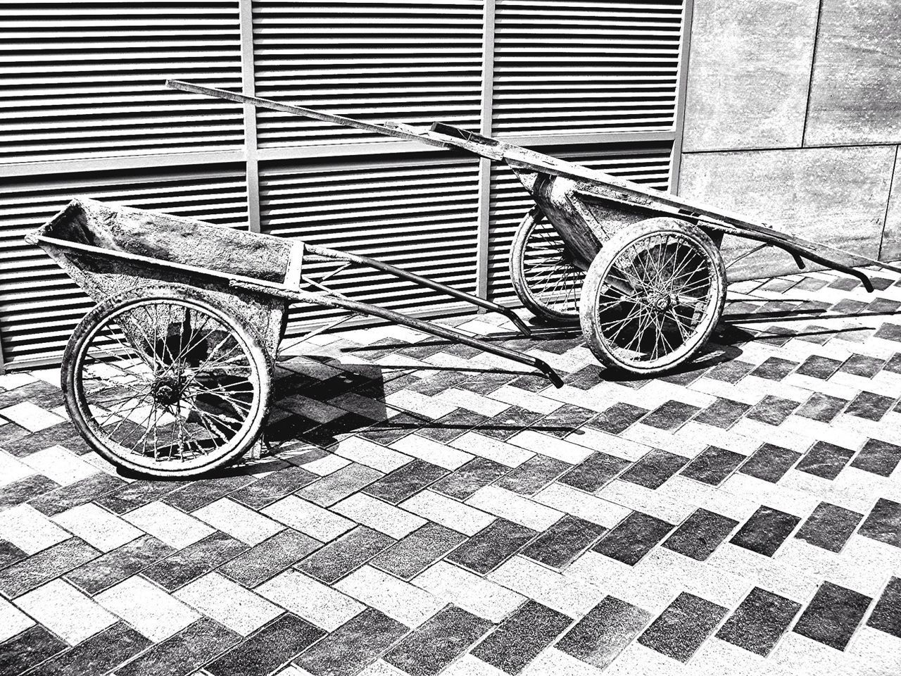 Side view of wheelbarrows on stone tile ground