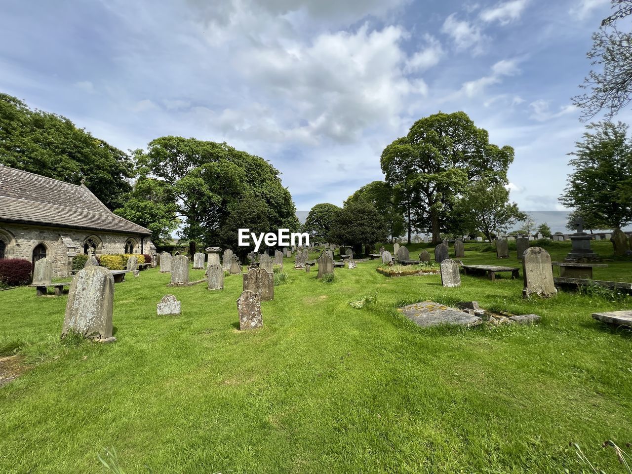 View over a peaceful graveyard, next to an old church, in the village of, long preston, skipton, uk