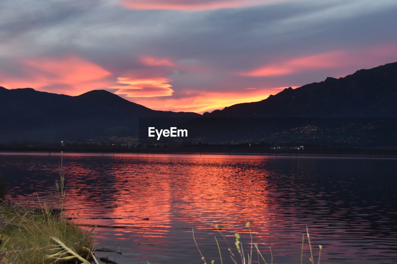 Scenic view of lake against orange sky