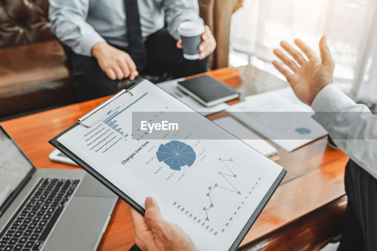 Cropped image of business colleagues working at desk in office