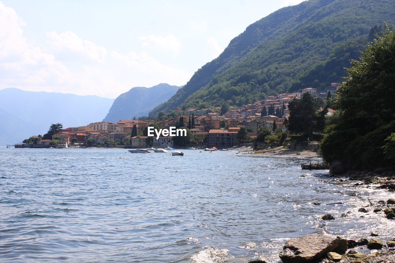 Scenic view of river by mountains against sky