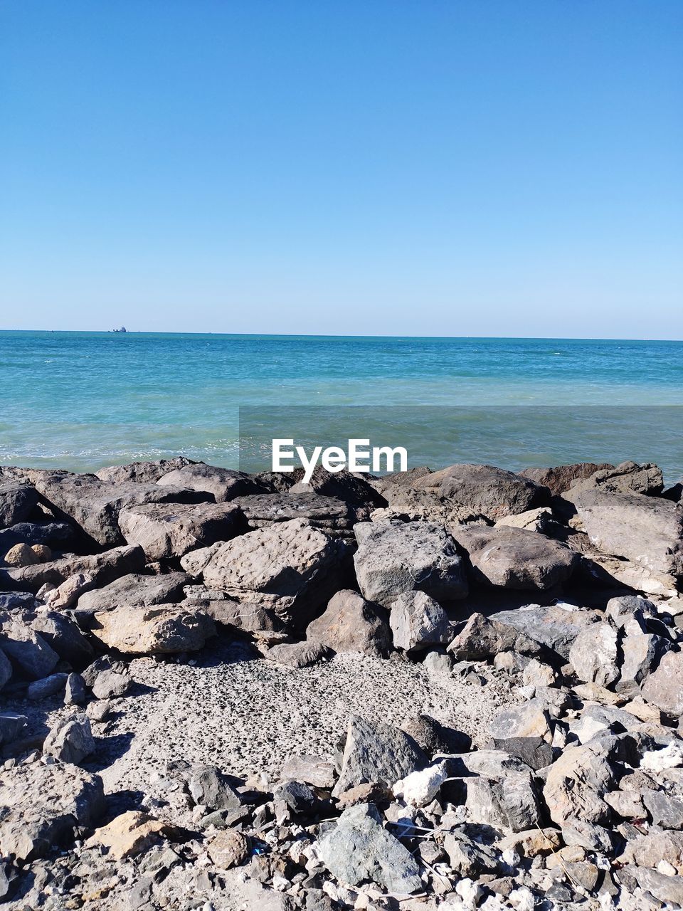 Scenic view of beach against clear blue sky