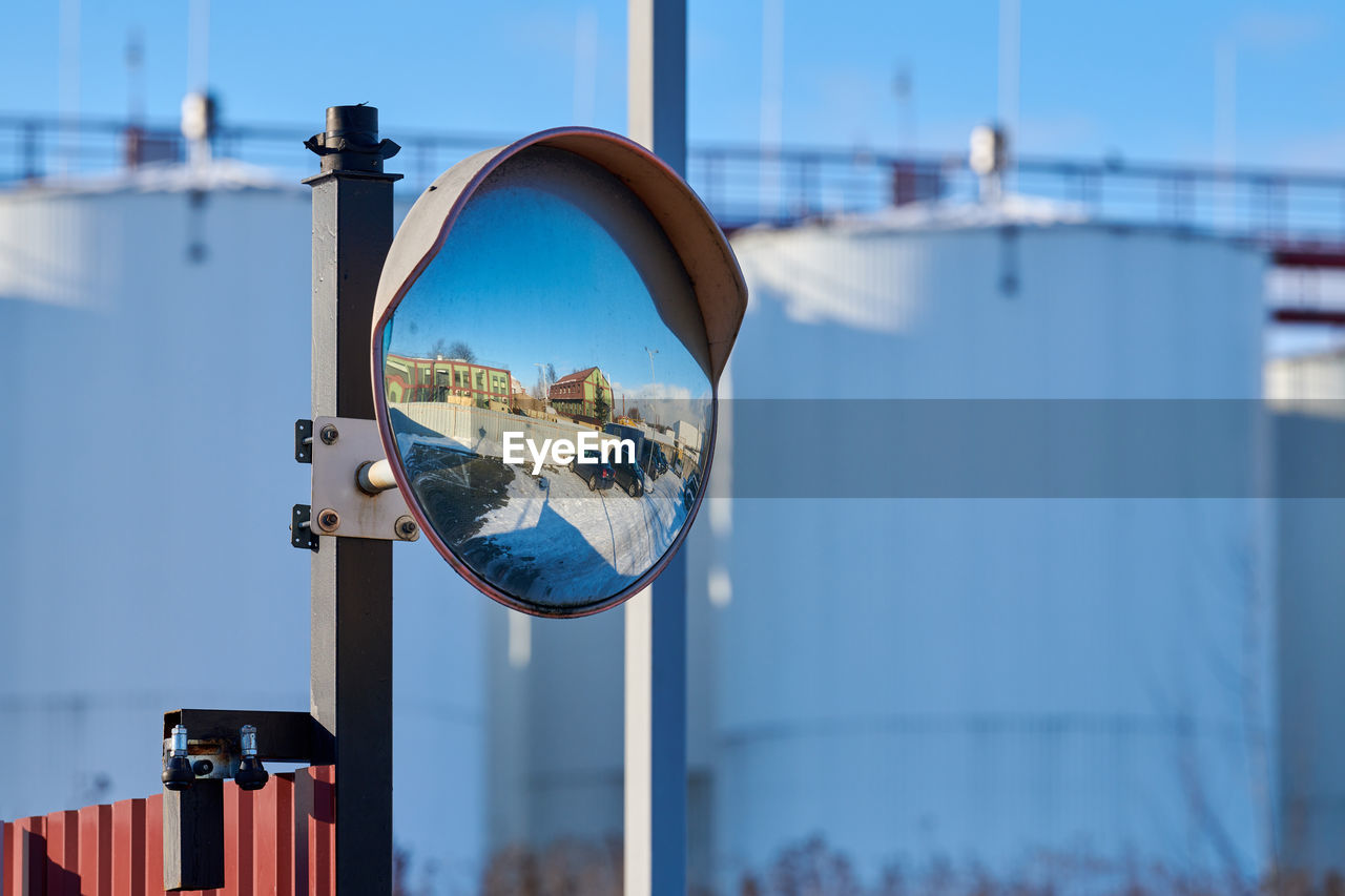 Mirror of spherical type on telegraph pole reflecting road. large convex mirror on road