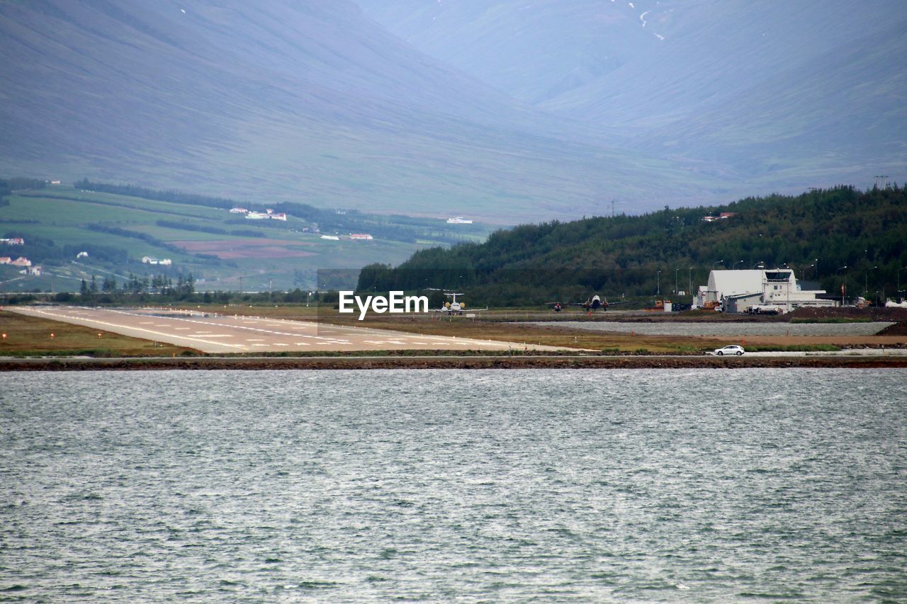 Scenic view of sea and mountains against sky